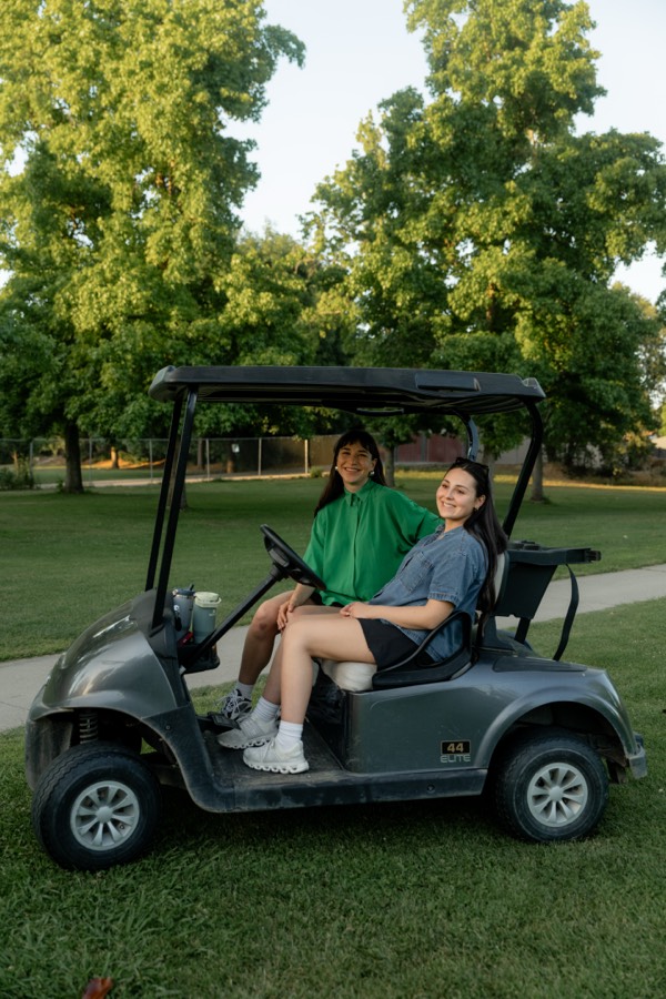 Golfers in a cart beside the ocean